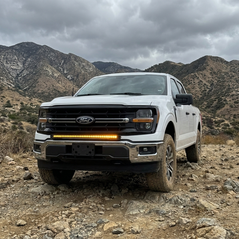 2024+ Ford F150 LightBar mounted on a white Ford F150 in a rugged mountain landscape.