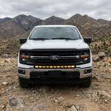2024+ Ford F150 LightBar mounted on a white Ford F150 in an off-road setting with mountains in the background.