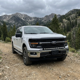 2024+ Ford F150 LightBar installed on a white truck in a mountainous off-road setting.