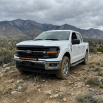 2024+ Ford F150 LightBar installed on a white Ford F150 in a rugged outdoor setting.