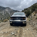2024+ Ford F150 LightBar installed on a Ford F150 driving through rocky terrain.