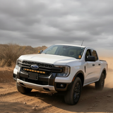 White Ford Ranger running the hood-mounted Ditch Lights PRO while off-roading in the desert