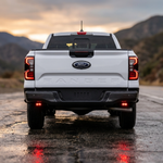 Rear of a white Ford Ranger with the reverse light kit pods showing red backlight