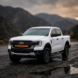 White Ford Ranger in a rugged outdoor setting with the grille-mounted 30-inch SLIM LED light bar