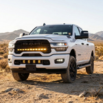 2025+ RAM 2500 40in PRO grille light bar with amber DRL lit on a white truck in the desert, front three-quarter view