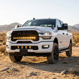2025+ RAM 2500 40in PRO grille light bar with amber DRL lit on a white truck in the desert, front three-quarter view