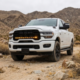 2025+ RAM 2500 40in PRO grille light bar with amber DRL lit on a white truck in the desert with mountains behind