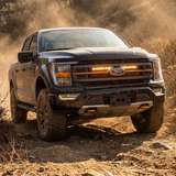 2021-2023 Ford F150 Tremor kicking up dust with a single amber 30in LED light bar lit behind the grille