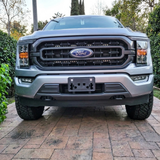 Front view of a 2021-2023 Ford F150 with dual 30in LED light bars installed behind the grille, lights off, showing a clean factory look