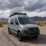 2019+ Mercedes Sprinter 4x4 van on a desert road with a 40in SLIM light bar mounted on top of the grille