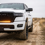 2026 RAM 1500 HEMI 40in light bar SLIM glowing bright amber in the grille on a dirt trail