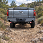 2024 Ford F-150 rear view on a dirt trail with LED reverse lights showing red backlight under the bumper