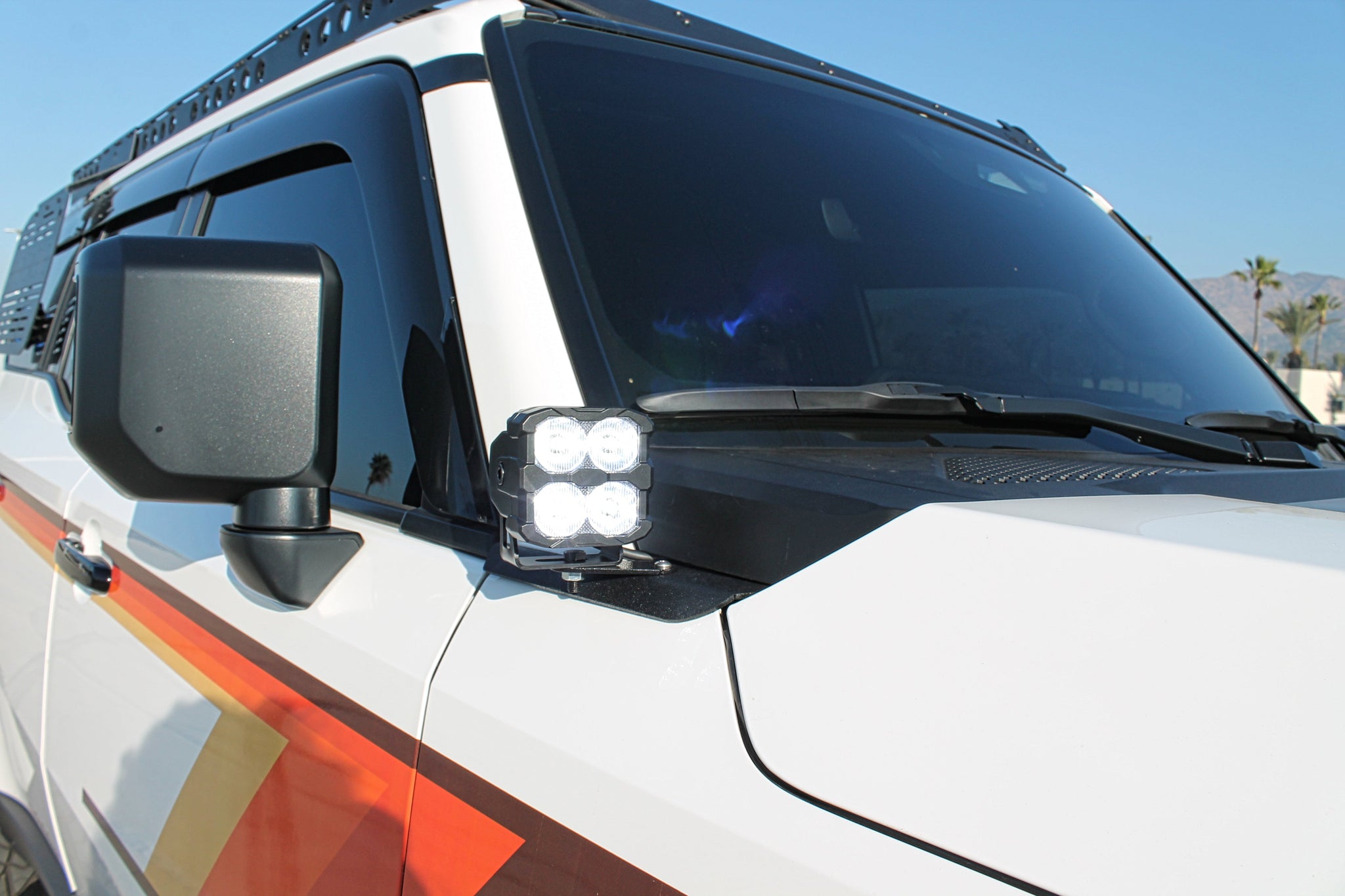 Land Cruiser ditch lights for 2024+ on white SUV with dual-color LEDs and amber DRL backglow