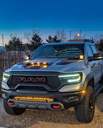 RAM TRX ditch lights on 2019-2024 RAM pickup with dual color white LED and amber DRL backglow, rugged front grille, and off-road lighting