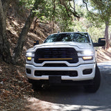 2025+ RAM 2500 light bar 40in slim curved LED installed on white RAM 2500 truck front grille on forest road