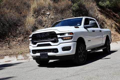 2025+ RAM 2500 light bar slim 40in curved LED installed on white RAM 2500 truck driving on mountain road