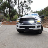 2025+ RAM 2500 light bar 40in PRO curved LED installed on white RAM 2500 truck front view on mountain road