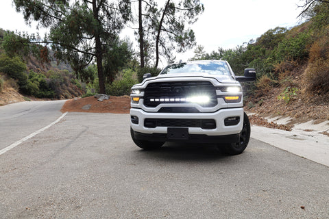 2025+ RAM 2500 light bar 40in PRO curved LED installed on white RAM 2500 truck front view on mountain road