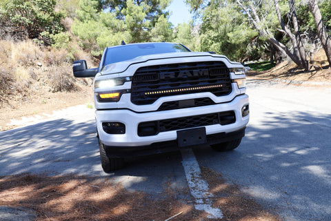 2025+ RAM 2500 light bar 40in slim curved LED grille mount on white RAM 2500 truck front view on forest road