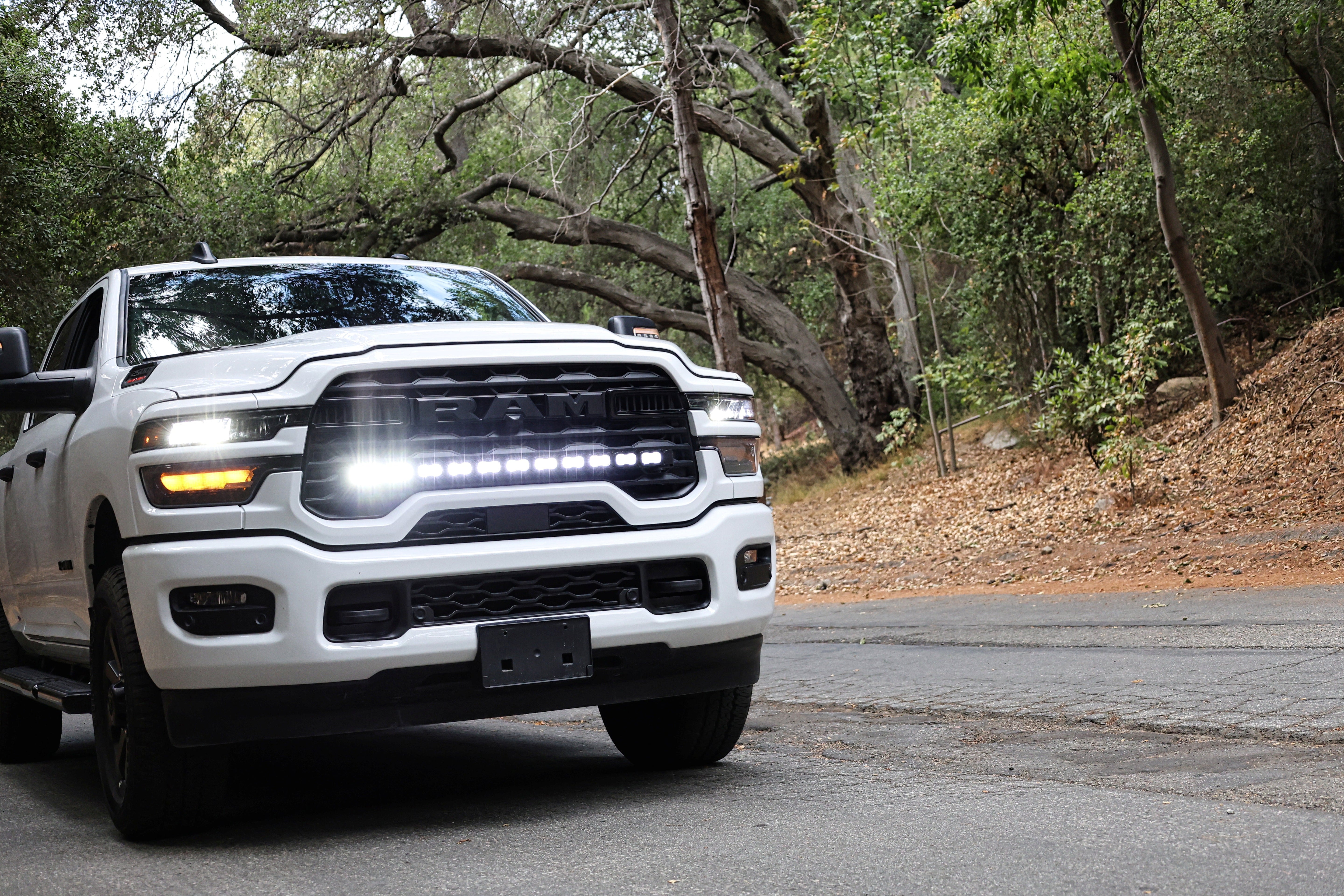 2025+ RAM 2500 light bar PRO 40in curved LED grille mount on white RAM 2500 truck driving on forest road