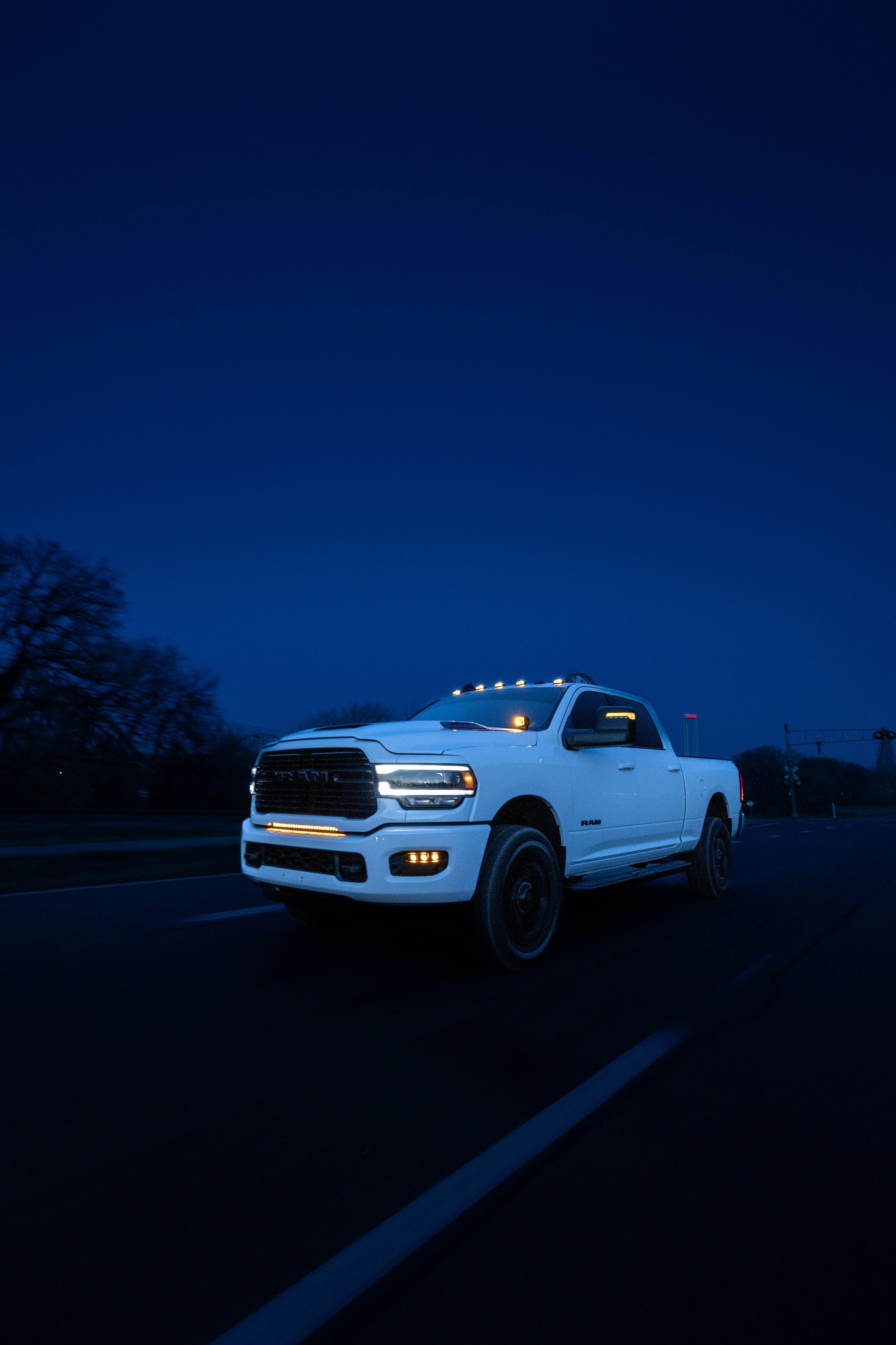 RAM 2500 Fog Light Kit installed on white RAM truck driving at night with bright LED fog lights on highway