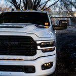 RAM 2500 Fog Light Kit installed on white RAM 2500 truck showing bright LED fog lights and front grille at dusk