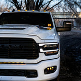 RAM 2500 Fog Light Kit installed on white RAM 2500 truck showing bright LED fog lights and front grille at dusk