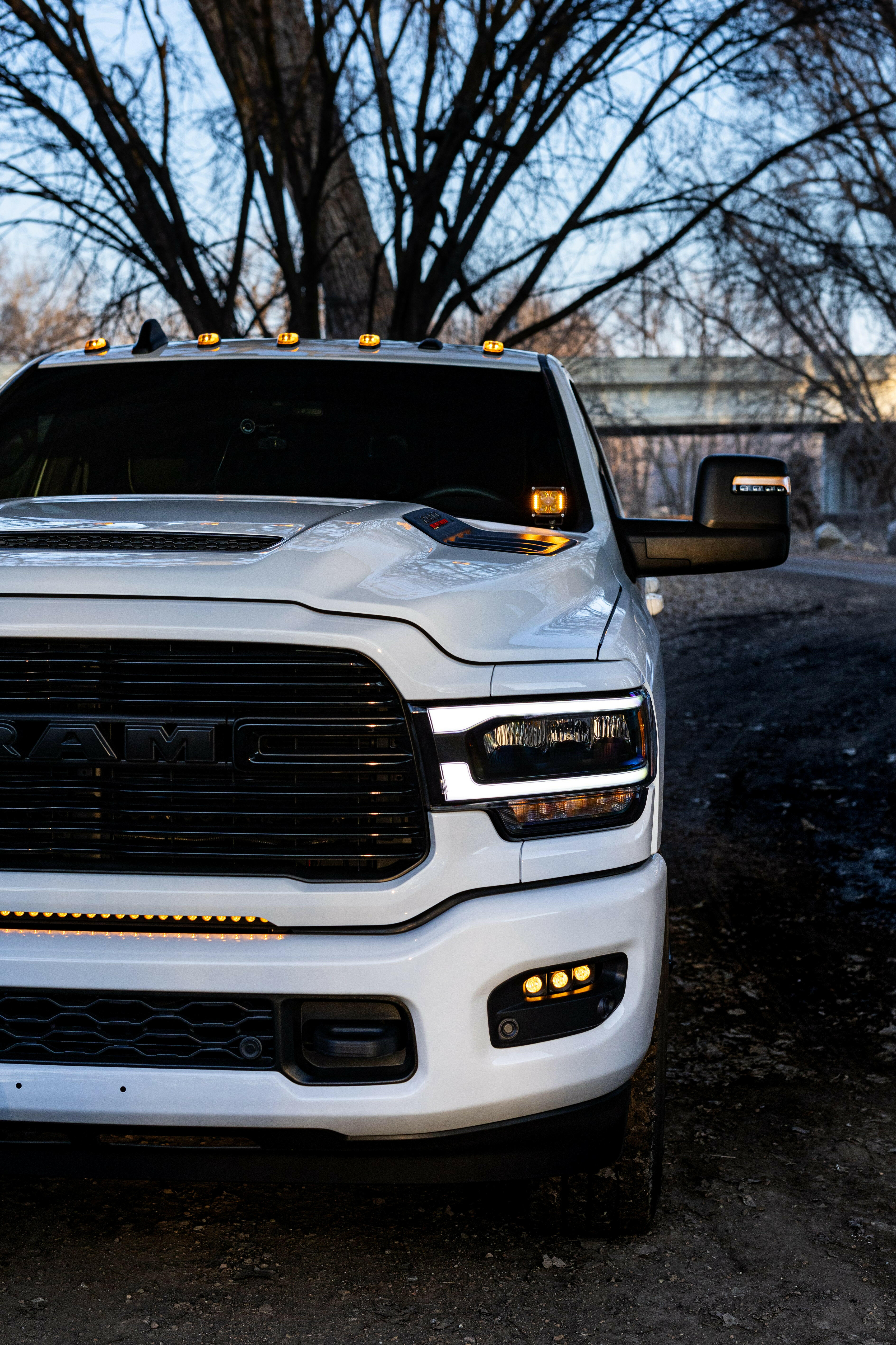RAM 2500 Fog Light Kit installed on white RAM 2500 truck showing bright LED fog lights and front grille at dusk