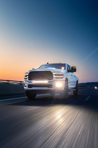 RAM 2500 Fog Light Kit installed on white RAM 2500 truck driving at dusk with bright LED fog lights on highway