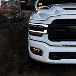 RAM 2500 Fog Light Kit installed on white RAM 2500 truck with amber LED fog lights illuminated at dusk