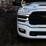 RAM 2500 Fog Light Kit installed on white RAM 2500 truck with amber LED fog lights illuminated at dusk