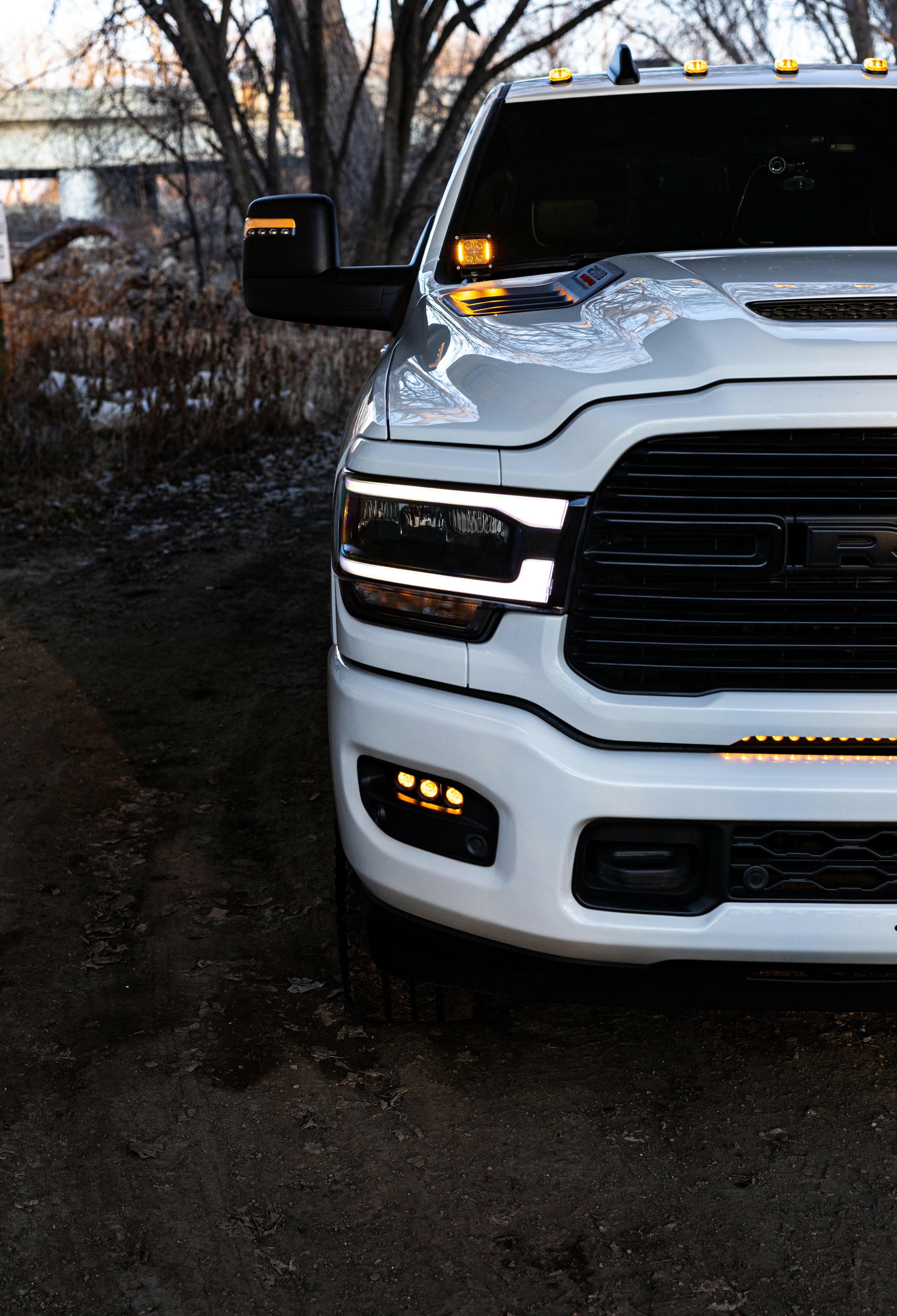 RAM 2500 Fog Light Kit installed on white RAM 2500 truck with amber LED fog lights illuminated at dusk