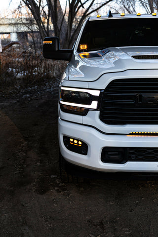 RAM 2500 Fog Light Kit installed on white RAM 2500 truck with amber LED fog lights illuminated at dusk