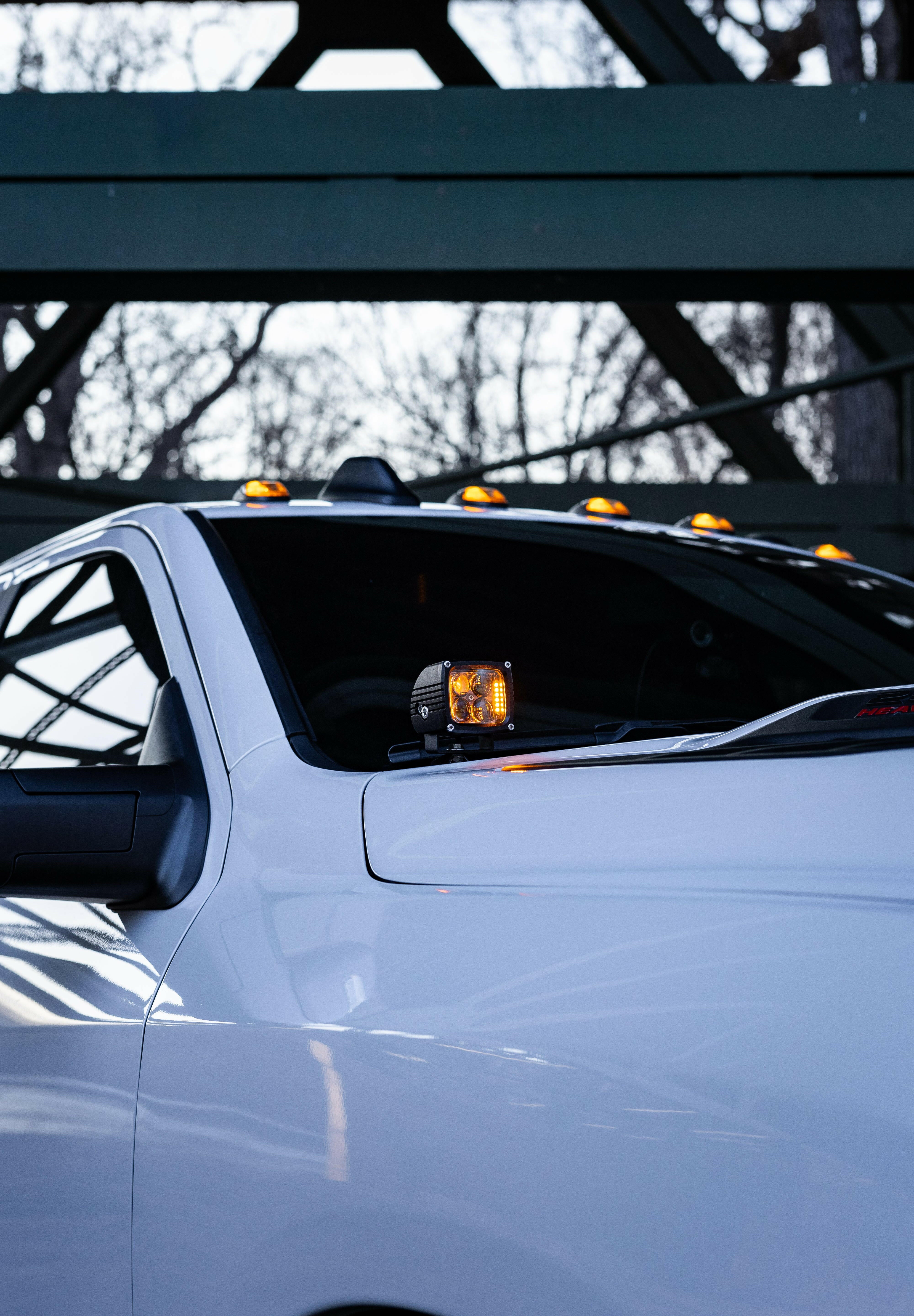 2025+ RAM 2500 3500 Ditch Lights with dual color amber DRL mounted on white truck cowl for improved off-road visibility