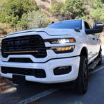 2025+ RAM 2500 light bar slim 40in curved LED installed on white RAM 2500 truck front grille on mountain road