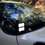 2025+ RAM 2500 & 3500 Ditch Lights PRO dual white LED pods mounted by windshield on white RAM truck