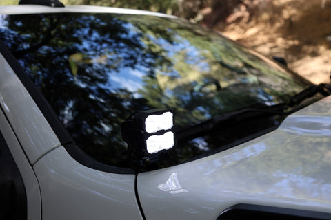 2025+ RAM 2500 & 3500 Ditch Lights PRO dual white LED pods mounted by windshield on white RAM truck