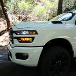 2025+ RAM 2500 light bar slim curved LED on white RAM 2500 truck front driver side in wooded road setting