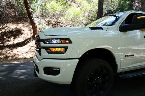 2025+ RAM 2500 light bar slim curved LED on white RAM 2500 truck front driver side in wooded road setting