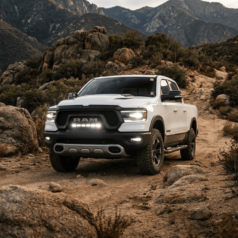 RAM REBEL light bar PRO installed on white RAM 1500 Rebel driving off-road between rocks at sunset