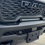 RAM RHO lightbar installed on 2025+ RAM 1500 Rebel, slim curved LED light between grille and bumper with black powder-coated metal bracket