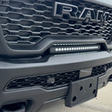 RAM RHO lightbar installed on 2025+ RAM 1500 Rebel, slim curved LED light between grille and bumper with black powder-coated metal bracket