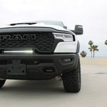 RAM RHO lightbar on 2025+ RAM 1500 Rebel between grille and bumper; slim curved light bar with black powder-coated bracket, 23in length