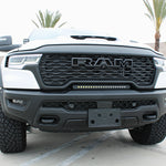 RAM RHO lightbar on 2025+ RAM 1500 Rebel — curved slim light bar between grille and bumper with black powder-coated bracket; RAM RHO lightbar