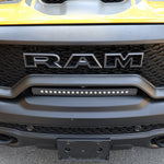 RAM TRX Light bar slim 23in curved LED mounted in factory grille opening on yellow 2021-2024 RAM 1500 TRX front bumper