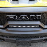 RAM TRX Light bar slim 23in curved LED mounted in factory grille opening on yellow 2021-2024 RAM 1500 TRX front bumper