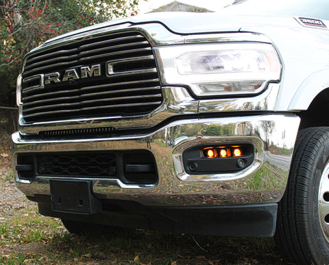 white ram 3500 with amber backglow fog light for off roading