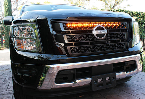 black nissan titan with one amber light bar behind the grille for off roading