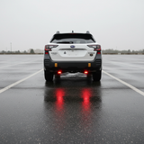 Subaru Outback reverse light kit on 2020-2024 Outback with bright LED pods and red backlight illuminated in wet parking lot