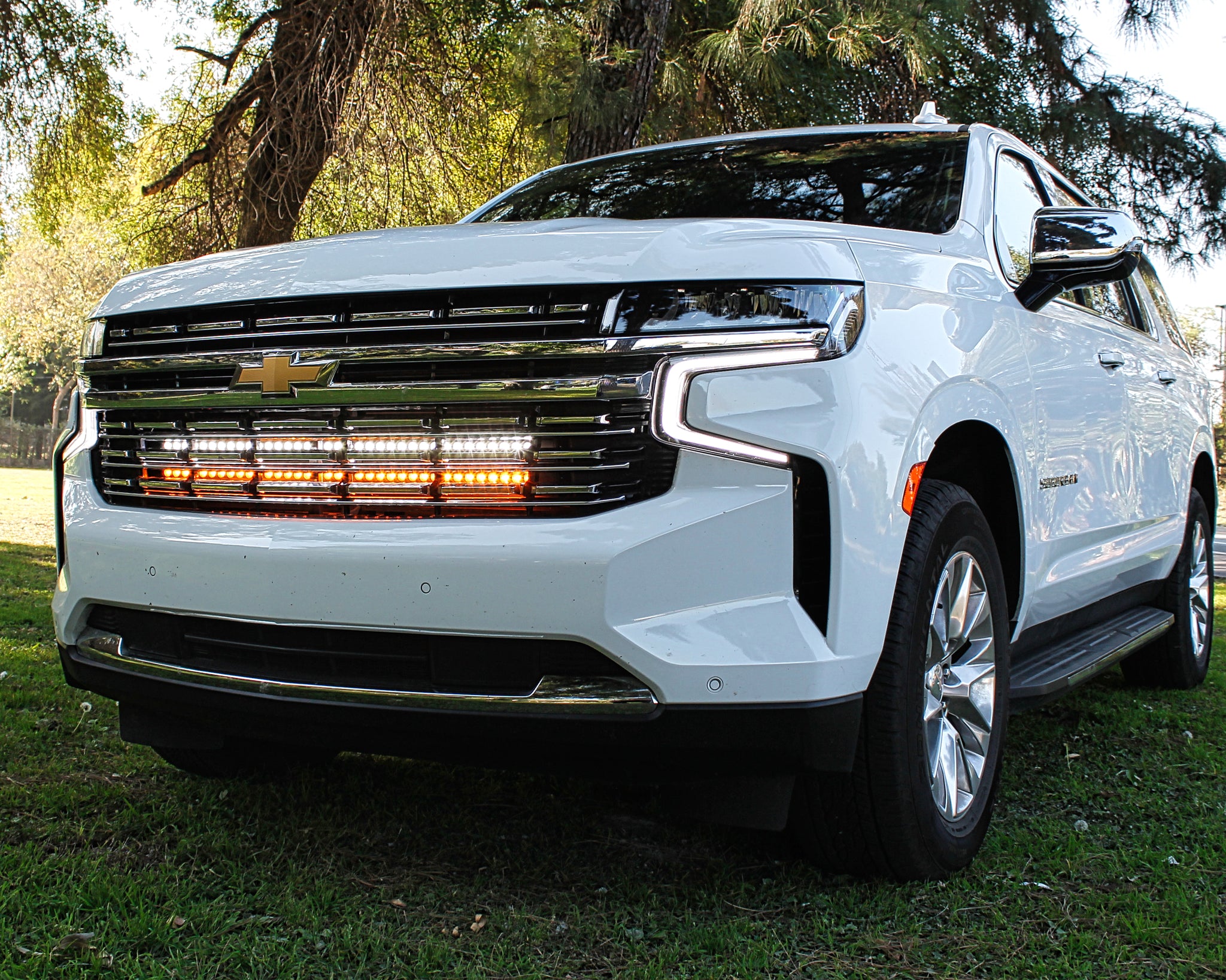 white 2021 2022 2023 2024 Chevrolet Suburban with 2 led lights bars behind the grille amber and white for off roading